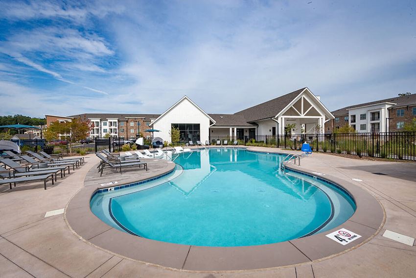 Swimming pool with large sundeck has lounge chairs at Pointe at Research Park - Photo Gallery 1