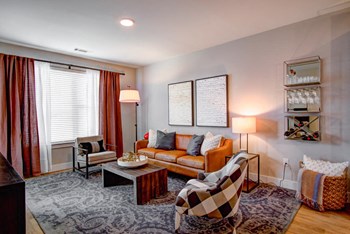 Large model living room furnished with a couch and 2 chairs at Pointe at Research Park apartments - Photo Gallery 5