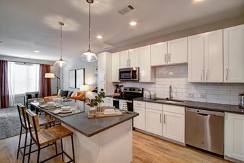 Model kitchen has a large island and stainless steel appliances at Pointe at Research Park apartments - Photo Gallery 3
