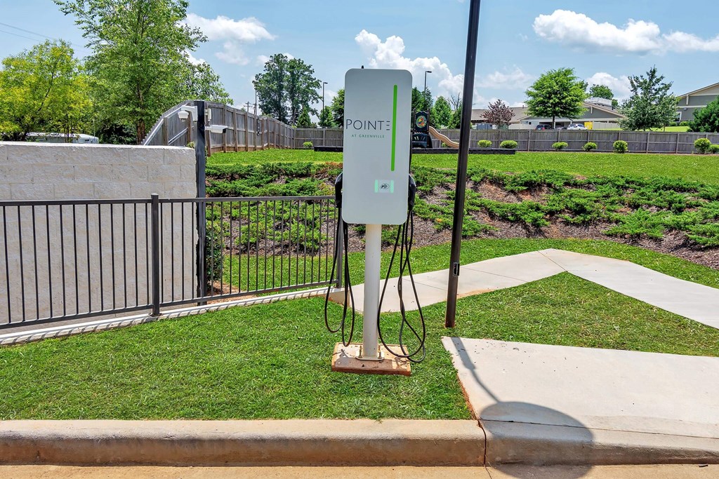 a power station on a grassy area with a fence and trees in the background