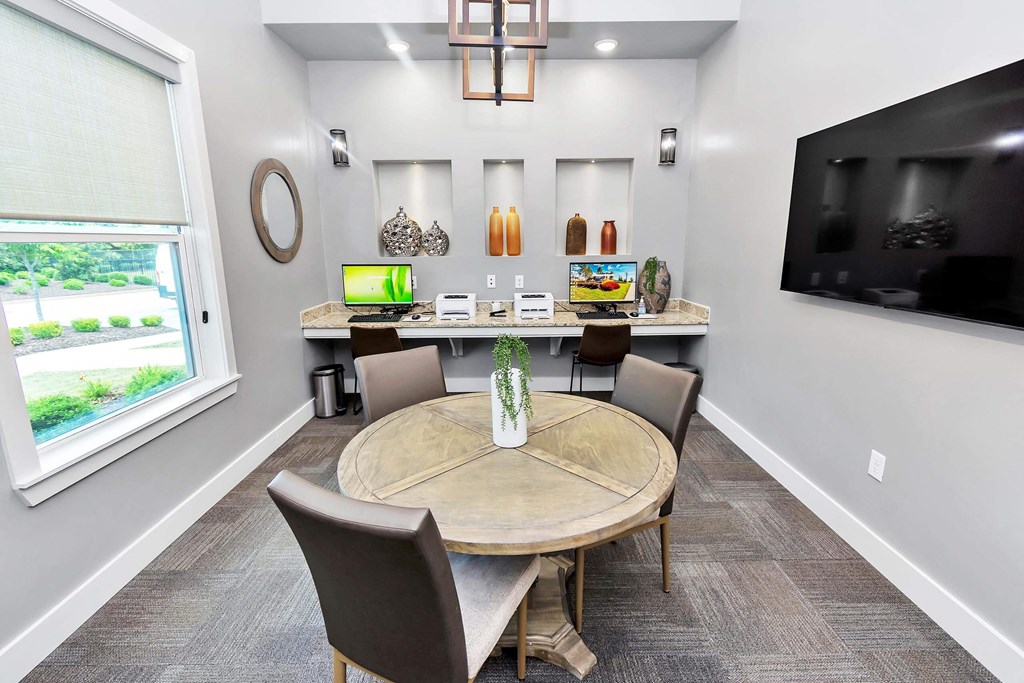a dining room with a table and chairs and a tv on the wall