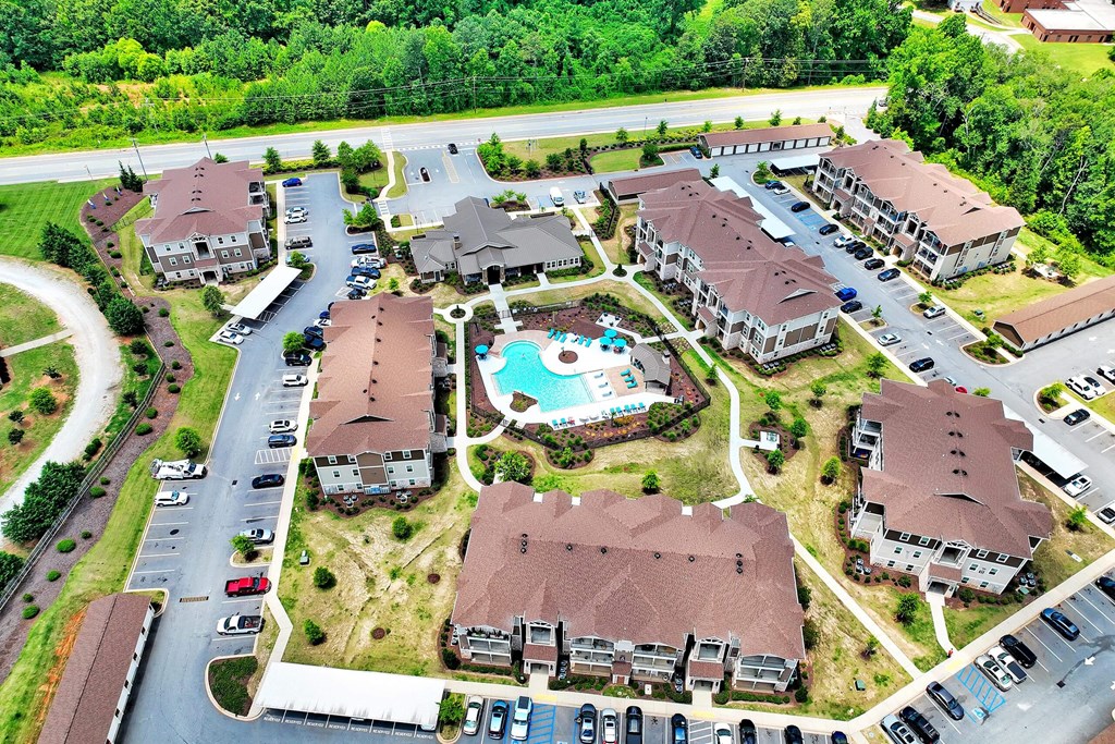 an aerial view of a large community of houses with a swimming pool in the middle of the