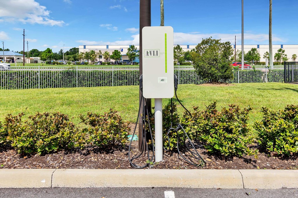 a power outlet on the side of a road with a green grassy field in the background