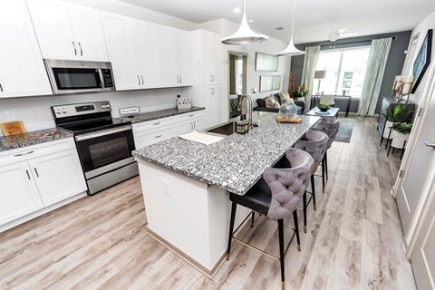an open kitchen and dining area with a marble counter top