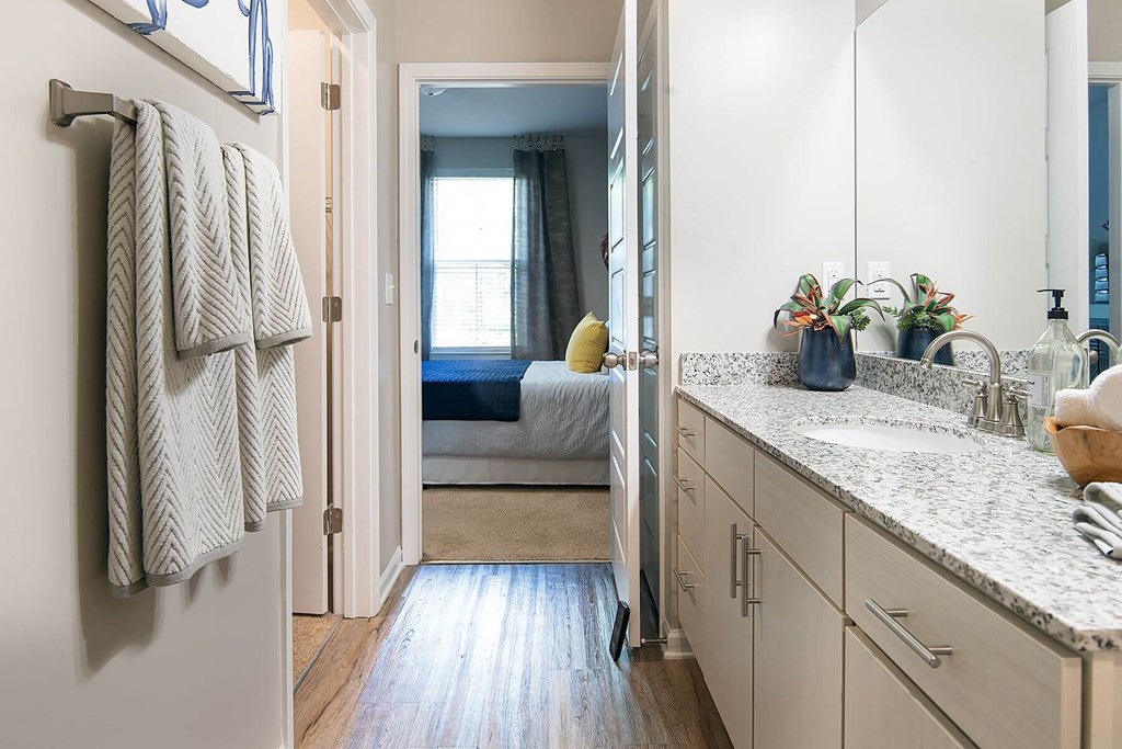 a bathroom with a sink and a door to a bedroom