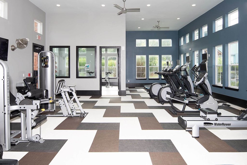 a workout room with treadmills and other exercise equipment