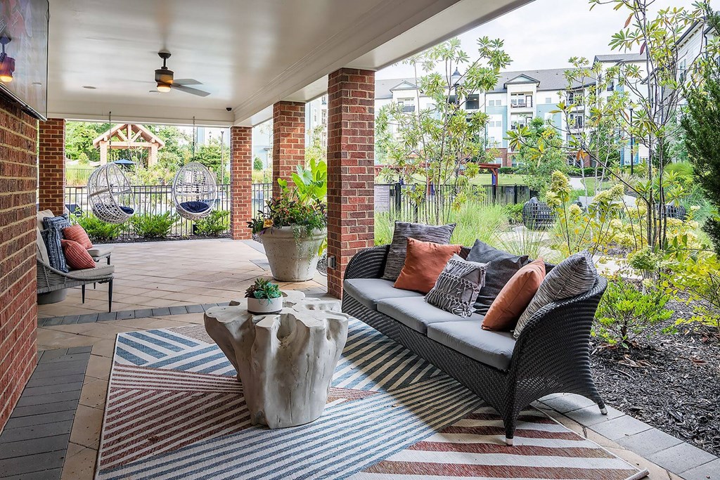 a covered patio with furniture and hammocks