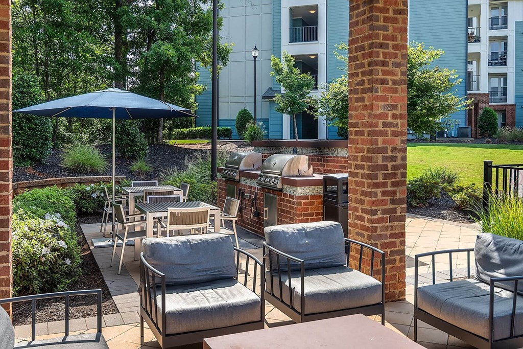 a patio with chairs and tables and an umbrella