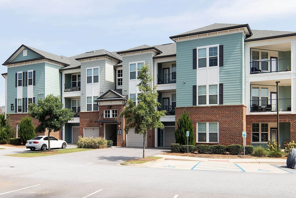 an apartment building with a white car parked in front of it