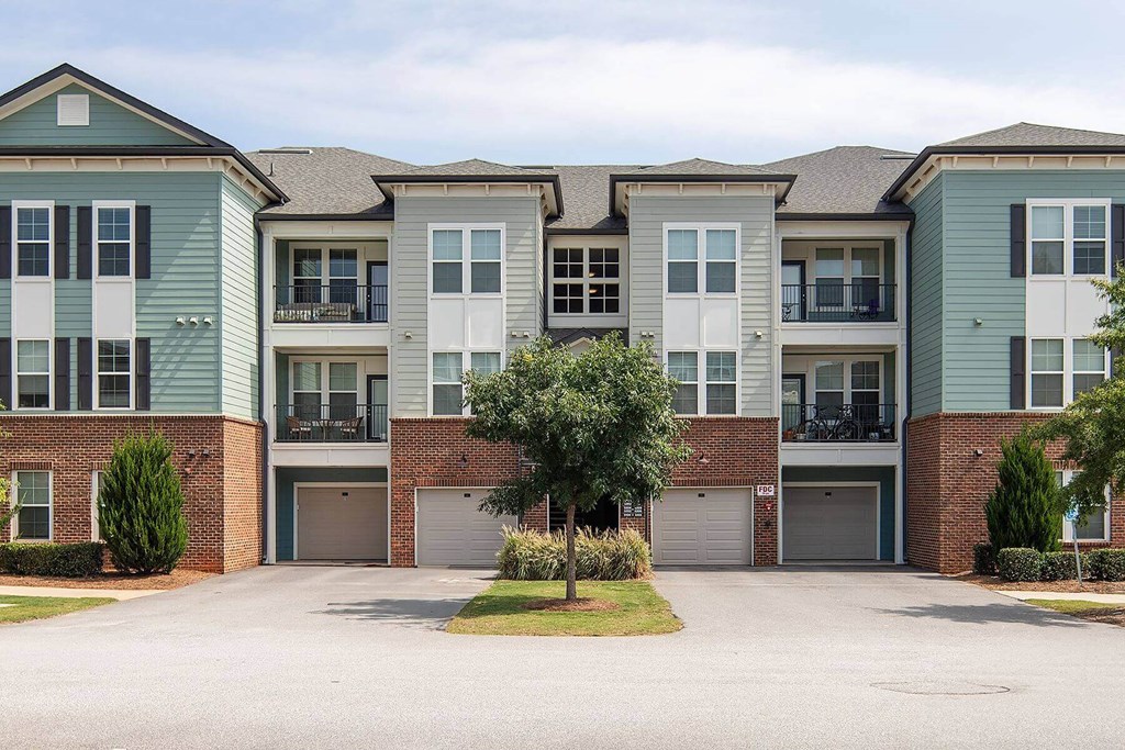 an exterior view of an apartment building with a driveway