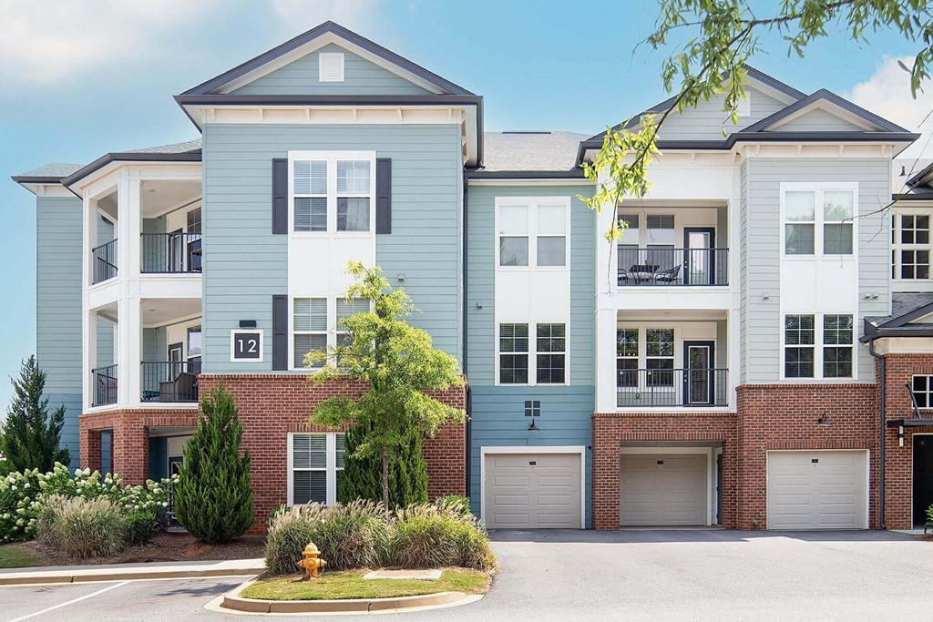 a street view of an apartment building with a parking lot