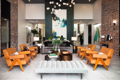 A living room with a white couch and orange chairs.