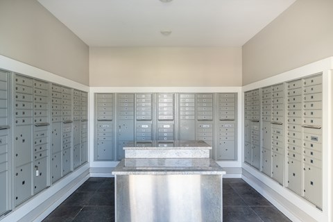 A room with a long table and a wall of mailboxes.