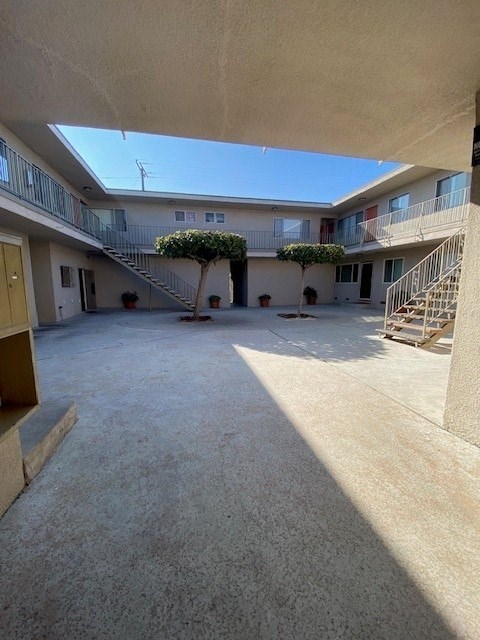 A courtyard with a tree and potted plants.