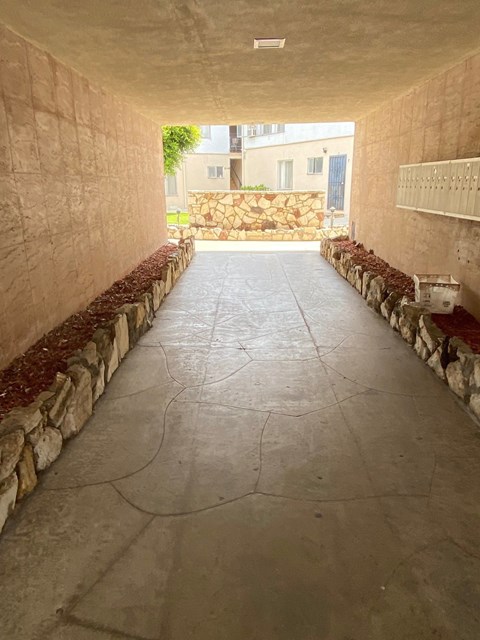 A long, narrow hallway with stone walls and a stone floor.