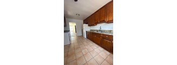 A kitchen with brown cabinets and a white refrigerator.