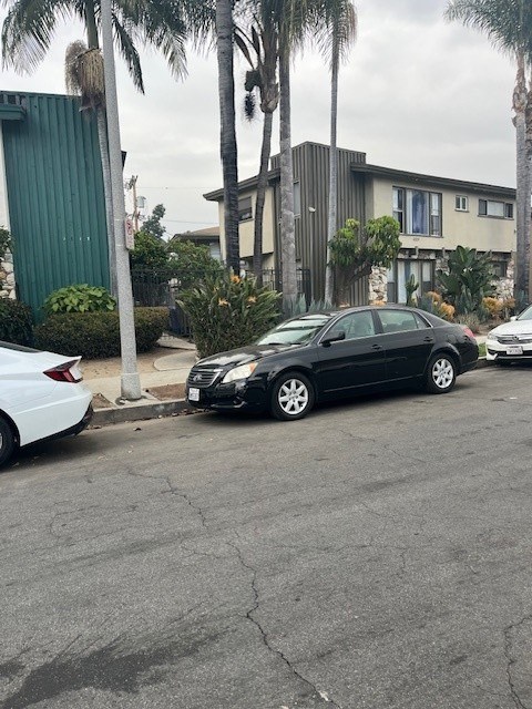 A black car is parked on the side of a street.