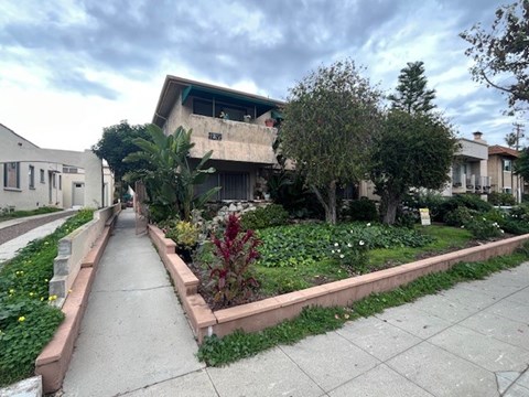 A residential street with a sidewalk and houses on either side.