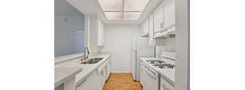 A kitchen with white cabinets and a stove top oven.