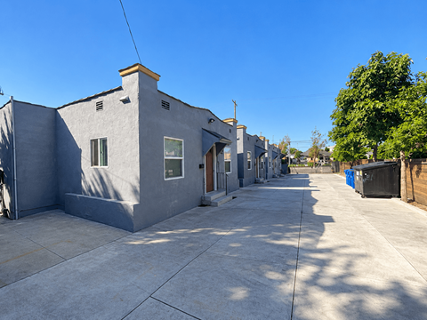 A row of grey houses with a clear blue sky above.