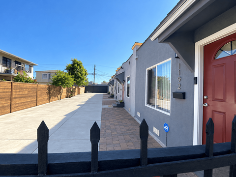 A row of houses with a red door and a blue sign on the wall.