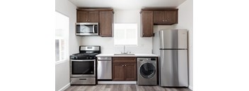 A kitchen with a stainless steel refrigerator, microwave, oven, and dishwasher.