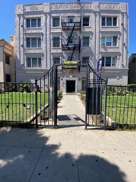 A tall building with a black gate in front.