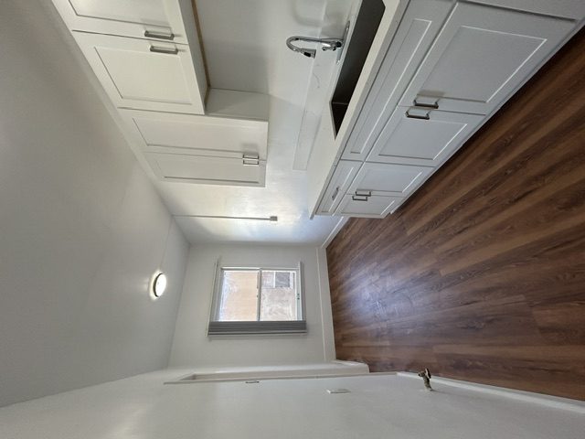 A room with a window and wooden wall.