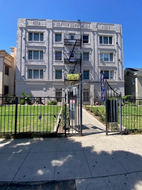 A white building with a black gate in front.