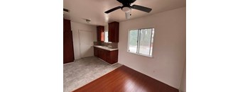 A room with a ceiling fan and wooden floors.
