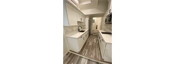 A kitchen with white cabinets and a sink.