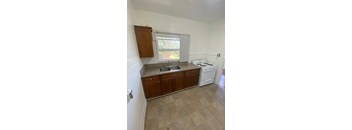 A kitchen with a white stove and a sink.
