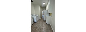 A kitchen with a white stove, dishwasher, and refrigerator.