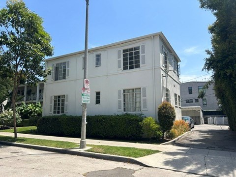 A white building with a no parking sign in front of it.