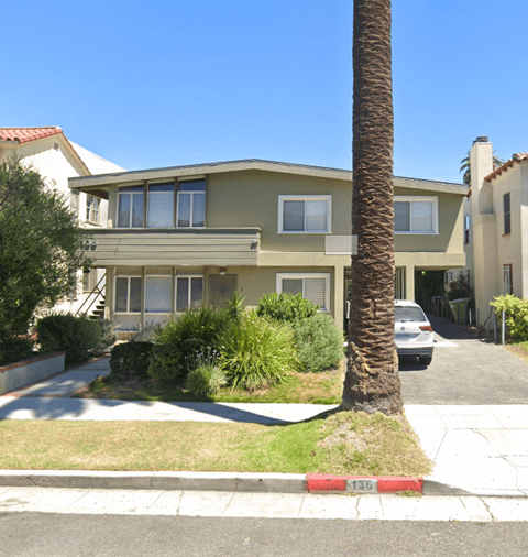 A house with a palm tree in front of it.