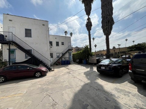 A parking lot with cars and a building with a staircase.