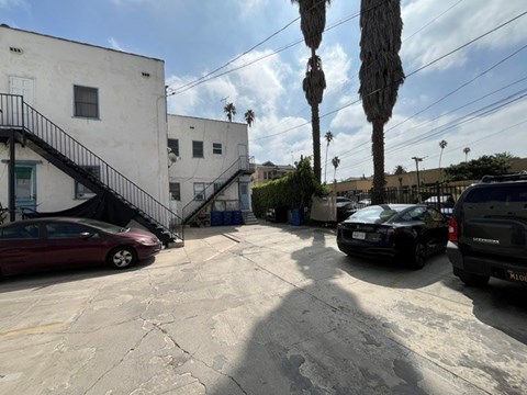 A parking lot with cars and a building with a staircase.