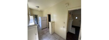A kitchen with white appliances and cabinets.