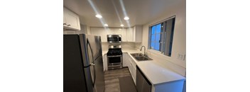 A modern kitchen with stainless steel appliances and white cabinets.