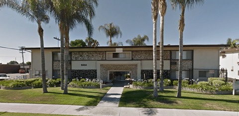 A building with palm trees in front of it.