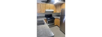 A kitchen with wooden cabinets and stainless steel appliances.
