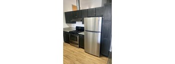 A kitchen with a stainless steel refrigerator, oven, and stove.