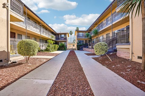 A long concrete pathway leads between two rows of buildings.