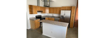 A kitchen with a white island and wooden cabinets.