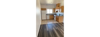 A kitchen with white appliances and wooden cabinets.