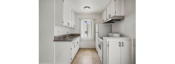 A kitchen with white cabinets and appliances.