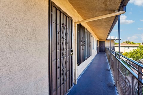 A long, narrow walkway with a metal railing and a closed gate.