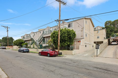 A red car is parked on the side of a street.