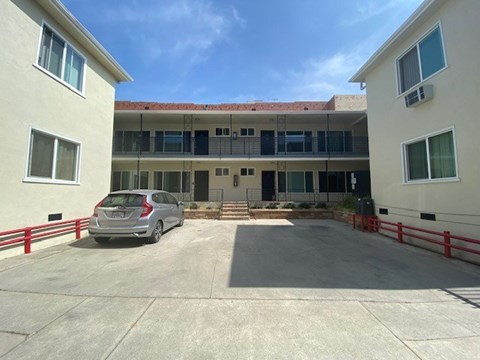 A car is parked in a parking lot in front of a building.