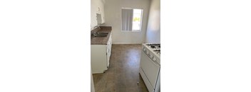 A kitchen with a white stove and a brown countertop.